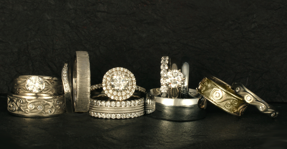 A selection of white gold wedding bands and engagement rings with diamonds.